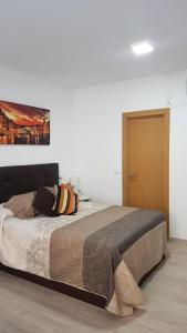トレモリノスにあるApartamento Silviaのベッドルーム1室(壁に絵画が描かれたベッド1台付)