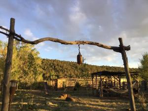Taos Goji Farm & Eco-Lodge Retreat في Arroyo Seco: فرع شجرة يتدلى من عمود في ميدان