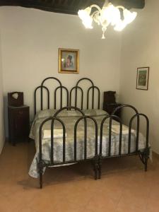 uma cama preta num quarto com um lustre em B&B Pozzo dei Desideri em Fisciano