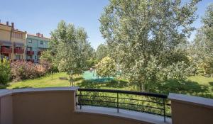 a balcony with a view of a park with trees at Appartamento Viserba mare/fiera in Rimini