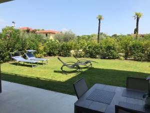 a lawn with two chairs and a table on it at Garda Dream Holiday in Sirmione