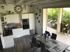 a kitchen with a table and a clock on the wall at Garda Dream Holiday in Sirmione