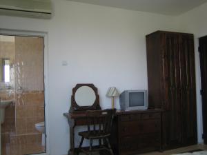 a bathroom with a desk with a tv and a mirror at Guest House Fanari in Sozopol