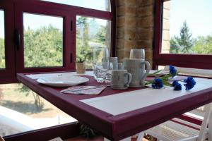 mesa de comedor con mantel blanco y flores azules en Il Profumo della Natura B&B en Oriolo Romano