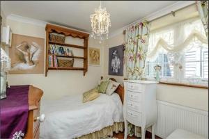 a bedroom with a bed and a dresser and a window at Little Croft in Haddenham