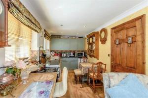 eine Küche und ein Wohnzimmer mit einem Tisch und einer Theke in der Unterkunft Little Croft in Haddenham