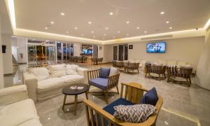 a living room with a couch and chairs and a table at Protaras Plaza Hotel in Protaras