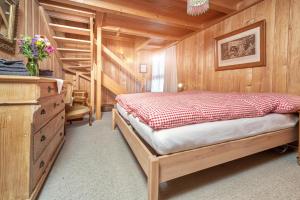 a bedroom with a bed and a wooden wall at BnB DeHeimelig in Huttwil