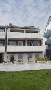 a large white building with windows and a lawn at Ferienwohnung Ol Komede Wai 12c in Helgoland