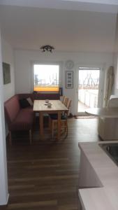 een keuken en een woonkamer met een tafel en een bank bij Ferienwohnung Ol Komede Wai 12c in Helgoland