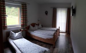 a bedroom with two beds and a window at Ferienwohnung Alpklang in Untertauern