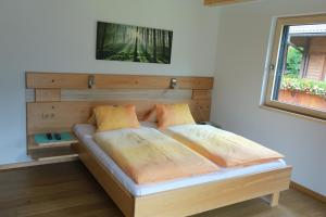 - une chambre avec un lit et une tête de lit en bois dans l'établissement Ferienwohnung Josef Pötscher, à Matrei in Osttirol