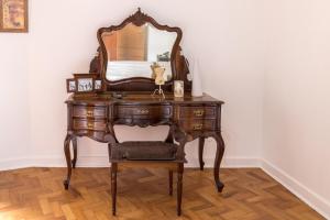 a wooden dressing table with a mirror and a chair at Apartamento Seaviews in São Vicente