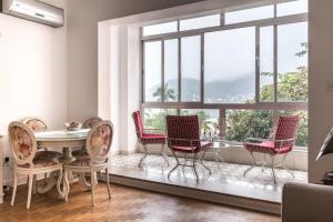 um quarto com cadeiras, uma mesa e uma grande janela em Apartamento Seaviews em São Vicente