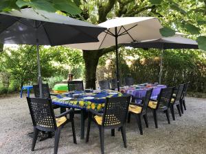 una mesa y sillas con sombrillas y platos. en Le Ribet, en Lempaut