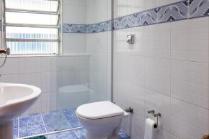 a white bathroom with a toilet and a sink at Apartamento Seaviews in São Vicente +45 photos