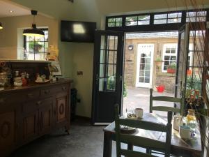 a kitchen with a table and chairs and a door at Rosemount Boutique B&B in Lanark