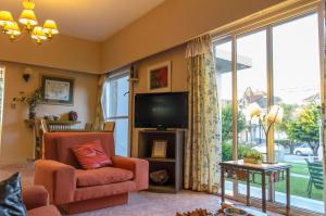 sala de estar con TV, silla y ventana grande en Hotel Marydor en La Falda
