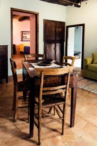 a dining room with a wooden table and chairs at Il Nibbio - Casa dell'artista in Morano Calabro