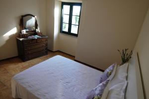 a bedroom with a bed and a dresser with a mirror at Angelas - Casa das Tias in Vila Praia de Âncora