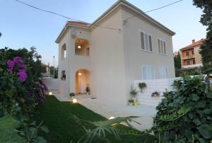 a white house with a pathway leading to a yard at The Bridge Casa Luxury Apartments in Zadar