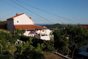 una casa blanca con una mesa en una colina en Apartments Krmek, en Dubrovnik