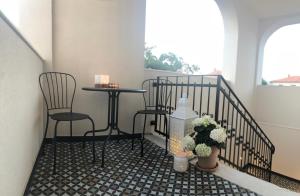 balcón con mesa, 2 sillas y ventana en The Bridge Casa Luxury Apartments, en Zadar