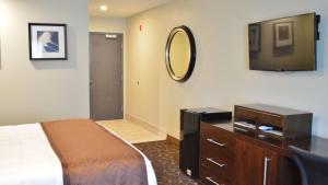 a bedroom with a bed and a tv and a dresser at America's Best Value Inn - Memphis Airport in Memphis