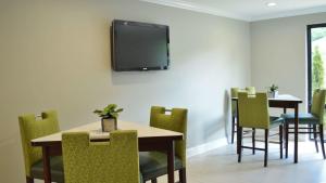 a dining room with a table and chairs and a tv on the wall at America's Best Value Inn - Memphis Airport in Memphis