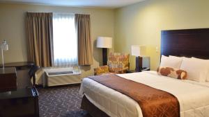 a hotel room with a large bed and a chair at America's Best Value Inn - Memphis Airport in Memphis