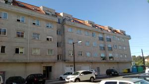 a large building with cars parked in front of it at Marvera in Caldas de Reis