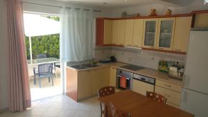 a kitchen with a table and a dining room at Kamares Apartments ΕΕ in Poros