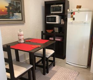 una pequeña cocina con mesa y nevera en You & Me Apartment, en Tandil