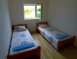 two beds in a small room with a window at Tonka in Sumartin