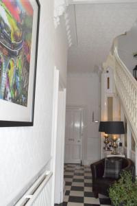 a hallway with a black chair and a painting on the wall at Edinburgh37 in Edinburgh
