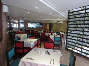 ブカラマンガにあるHotel León Doradoのダイニングルーム(白いテーブル、赤い椅子付)