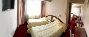 a hotel room with two beds and a couch at Americana Hotel in Cochabamba