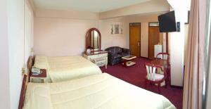 a hotel room with two beds and a mirror at Americana Hotel in Cochabamba