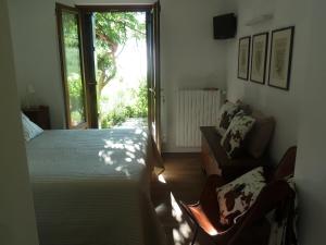sypialnia z łóżkiem, krzesłem i oknem w obiekcie La Pâquerette w mieście La Salle