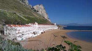 a beach with white buildings on the side of a mountain at Both Worlds Sandy Bay in Gibraltar