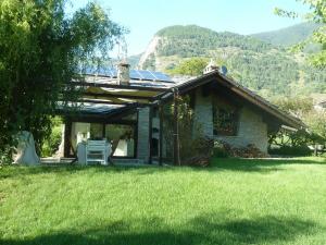 a house with a table and chairs in the grass at La Pâquerette in La Salle