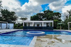 uma piscina com um pavilhão ao lado de uma casa em Hotel Finca Naranjal em Granada