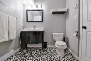 a white bathroom with a sink and a toilet at The Village Suites in Wellington