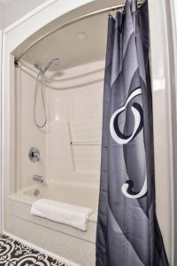 a shower curtain in a bathroom with a tub at The Village Suites in Wellington