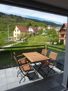 une table et des chaises en bois sur un balcon dans l'établissement Gites Chez Schangala, à Thannenkirch