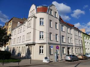 duży biały budynek z samochodami zaparkowanymi przed nim w obiekcie Ottimo Apartamenty Floriana w Bydgoszczy
