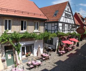 un edificio antiguo con mesas y sillas en una calle en Weinhotel Oechsle & Brix en Sommerhausen