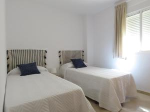 sypialnia z 2 łóżkami z białą pościelą i oknem w obiekcie Atico Torremolinos w mieście Torremolinos +34 zdjęcia