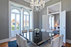 uma sala de jantar com uma mesa e cadeiras e um lustre em Saboia Terrace 515 by Saboia Collection em Monte Estoril