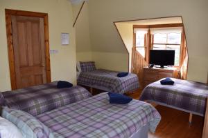 una camera con due letti e una tv di Ardgowan Guest House a Edimburgo